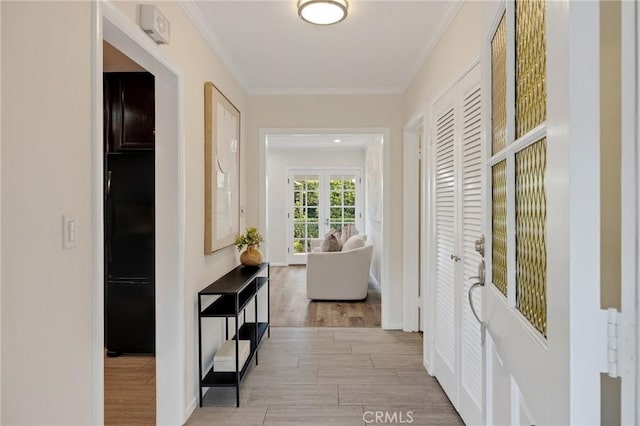 hall featuring ornamental molding and light hardwood / wood-style flooring