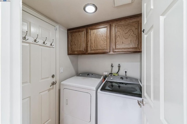 washroom with separate washer and dryer and cabinets