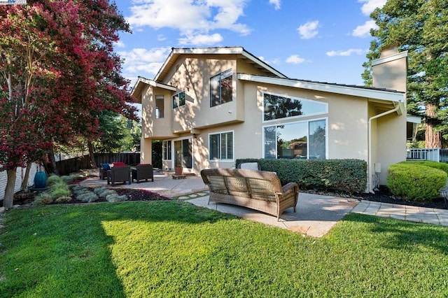 rear view of property with outdoor lounge area, a patio, and a lawn