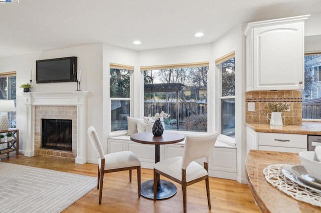 interior space featuring a tiled fireplace and light wood-type flooring