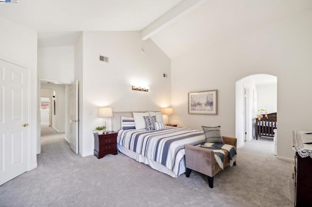 bedroom with beamed ceiling, high vaulted ceiling, and light carpet