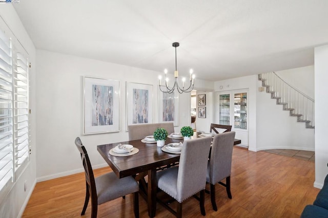 dining space featuring hardwood / wood-style flooring and a notable chandelier