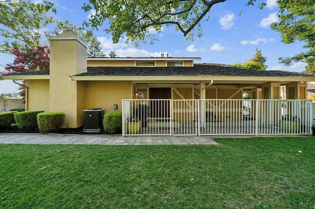 back of property featuring a yard and central air condition unit