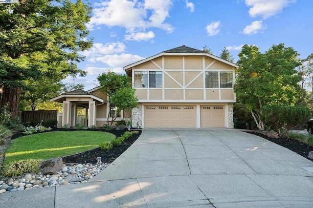 english style home featuring a garage and a front yard