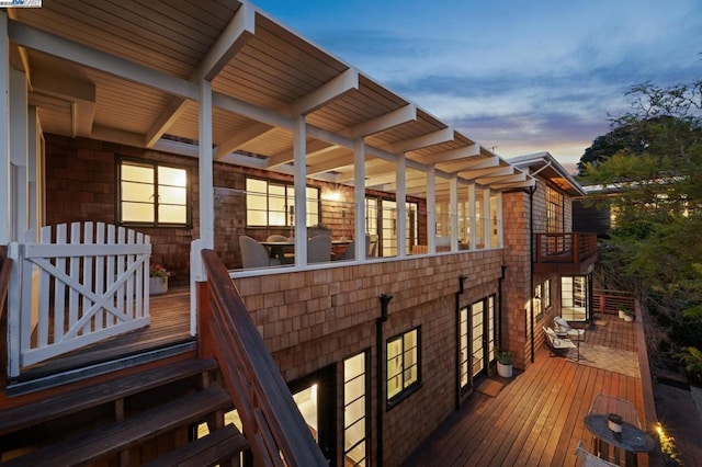 deck at dusk featuring a patio