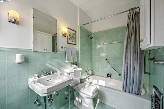 full bathroom featuring tile walls, sink, shower / bath combination with curtain, and toilet