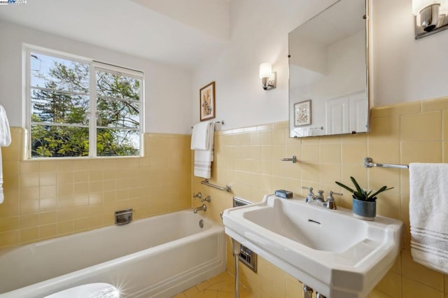 bathroom featuring tile walls, sink, tile patterned flooring, and a tub to relax in