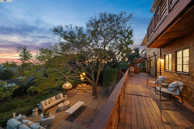 deck at dusk featuring an outdoor living space with a fire pit