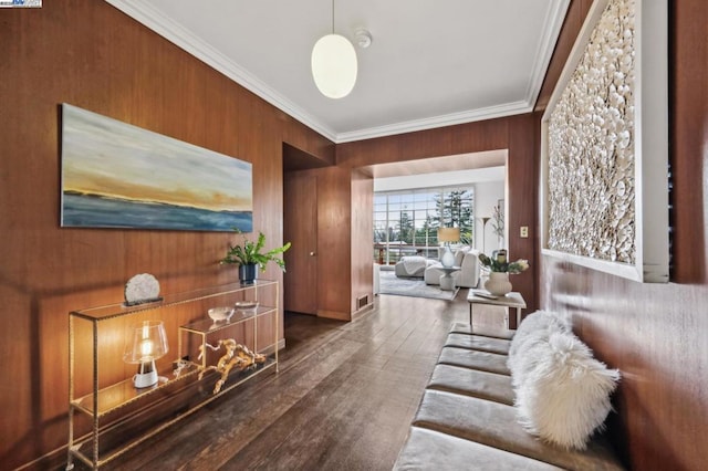 living room with crown molding, dark hardwood / wood-style flooring, and wood walls