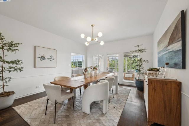 dining area featuring an inviting chandelier, wood-type flooring, and vaulted ceiling