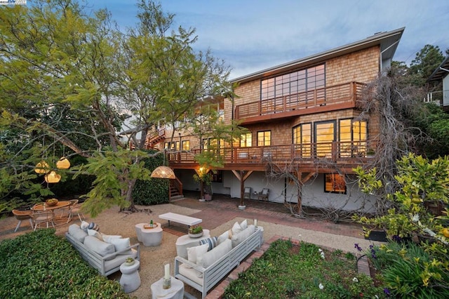 back of house featuring an outdoor living space with a fire pit and a deck