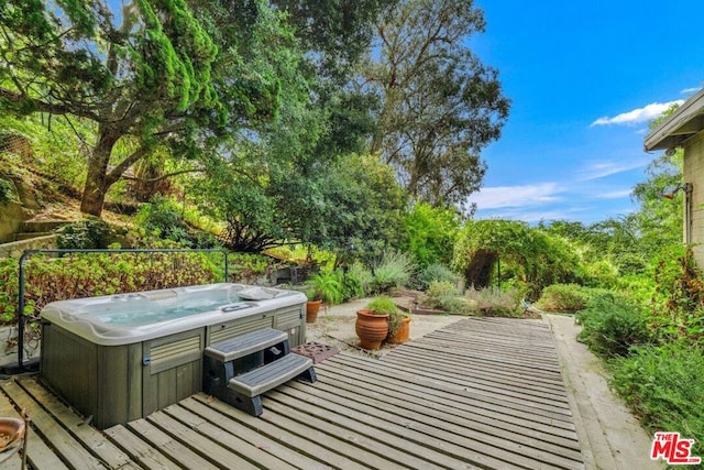 view of patio / terrace with a hot tub and a deck