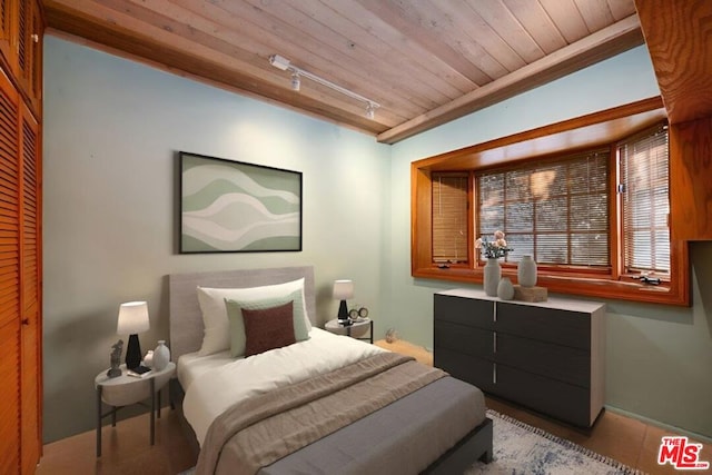 bedroom featuring track lighting and wooden ceiling