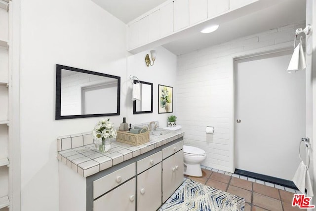 bathroom with tile patterned flooring, vanity, and toilet