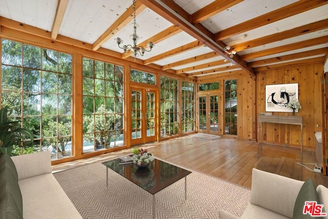 sunroom featuring french doors, a notable chandelier, beam ceiling, and a wealth of natural light