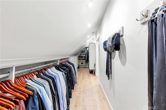 spacious closet with vaulted ceiling and light hardwood / wood-style floors