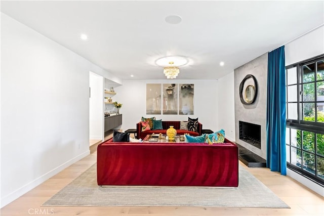 living room featuring a large fireplace and light hardwood / wood-style floors