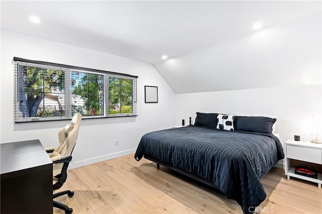 bedroom with vaulted ceiling and light wood-type flooring