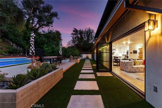 yard at dusk featuring a patio area