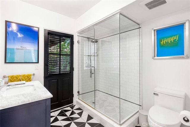 bathroom with vanity, toilet, and a shower with shower door