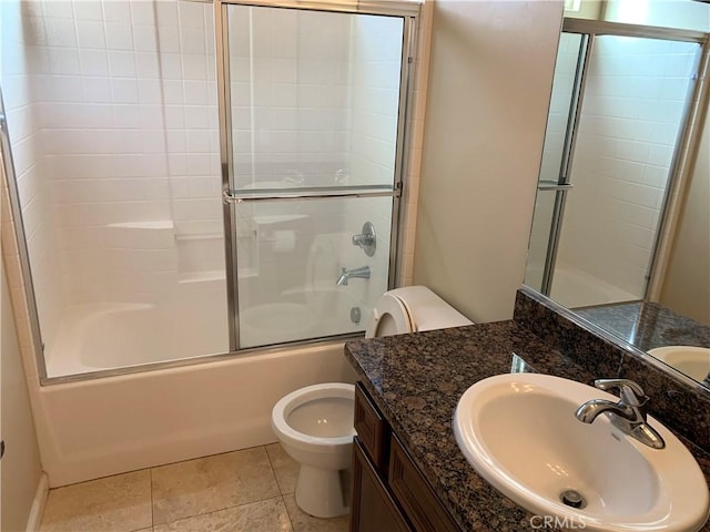 full bathroom featuring vanity, toilet, tile patterned flooring, and combined bath / shower with glass door