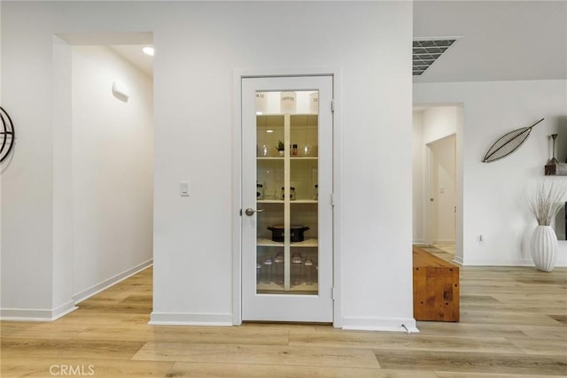 corridor with light hardwood / wood-style floors