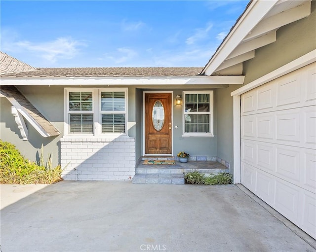 view of exterior entry featuring a garage and a porch