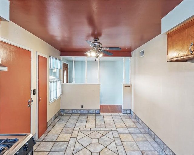 empty room featuring ceiling fan and ornate columns