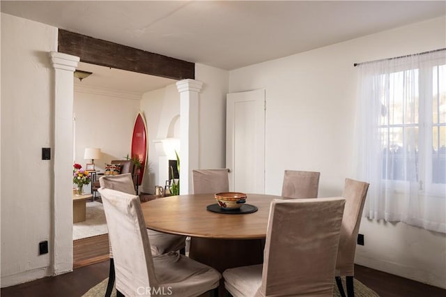 dining room featuring decorative columns and dark hardwood / wood-style floors