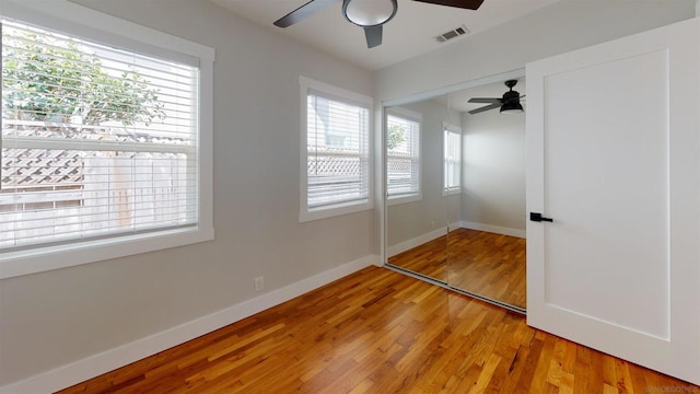 unfurnished bedroom with ceiling fan, wood-type flooring, and a closet