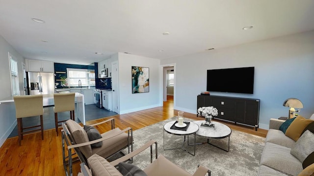 living room with sink and light hardwood / wood-style floors