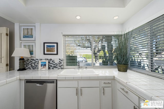 kitchen featuring dishwasher, sink, tile counters, and white cabinets