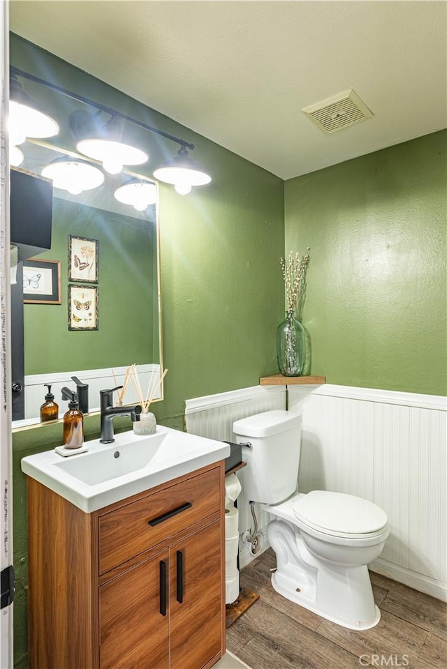 bathroom featuring vanity, toilet, and hardwood / wood-style floors