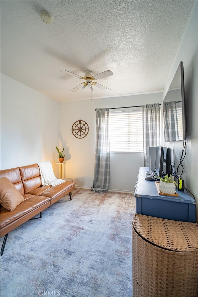 living room featuring ceiling fan, carpet floors, and a textured ceiling