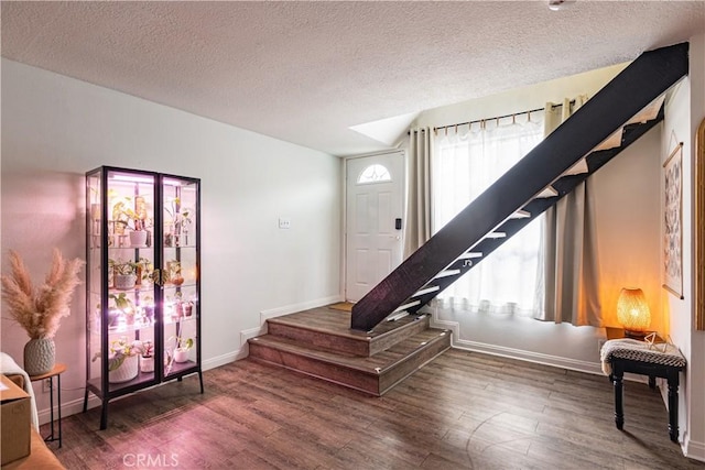 interior space with a textured ceiling, dark hardwood / wood-style floors, and a healthy amount of sunlight