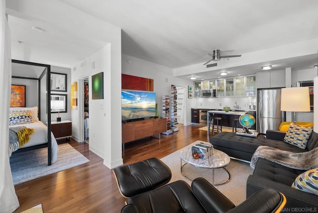 living room with wood-type flooring and ceiling fan