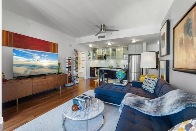 living room featuring dark wood-type flooring and ceiling fan