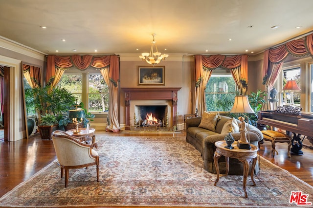 living room featuring dark wood-type flooring, ornamental molding, plenty of natural light, and a chandelier