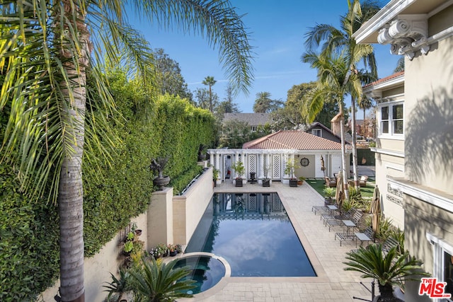 view of pool featuring a patio and an in ground hot tub