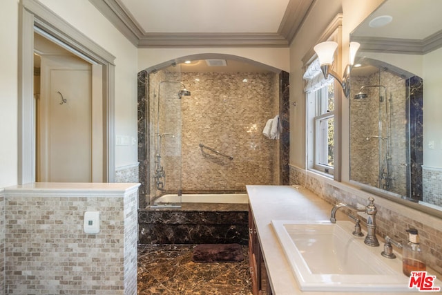 bathroom featuring tiled shower / bath, ornamental molding, and vanity