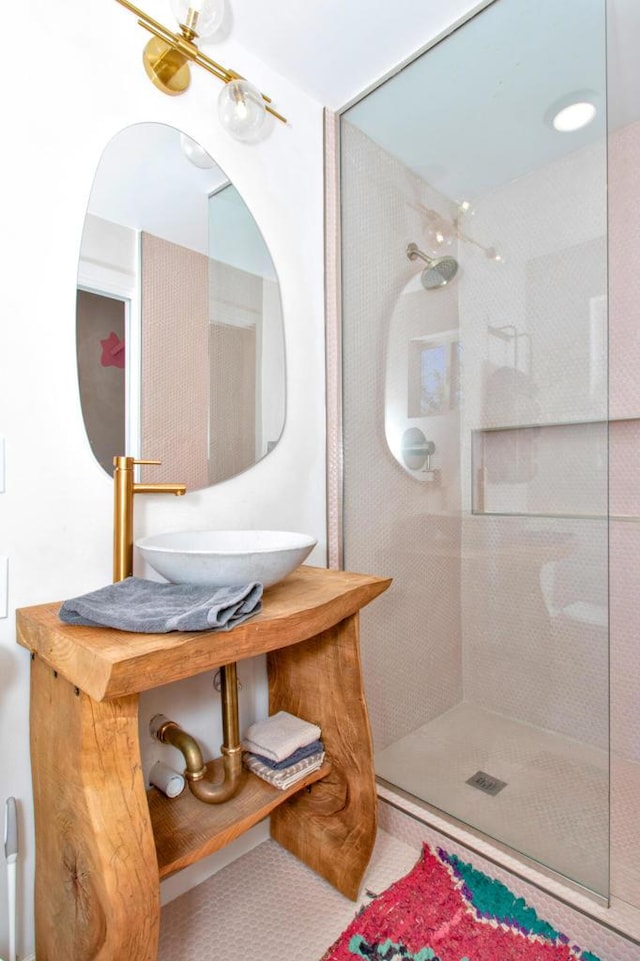 bathroom featuring sink and a tile shower