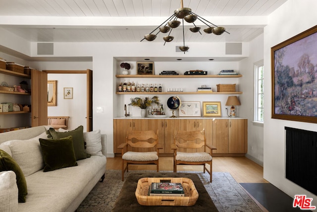 living room with built in features, beam ceiling, bar, wooden ceiling, and light wood-type flooring