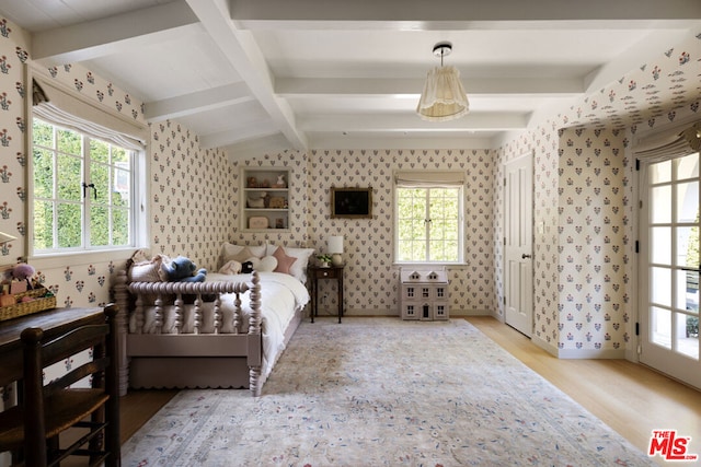 bedroom with multiple windows, vaulted ceiling with beams, and light hardwood / wood-style floors