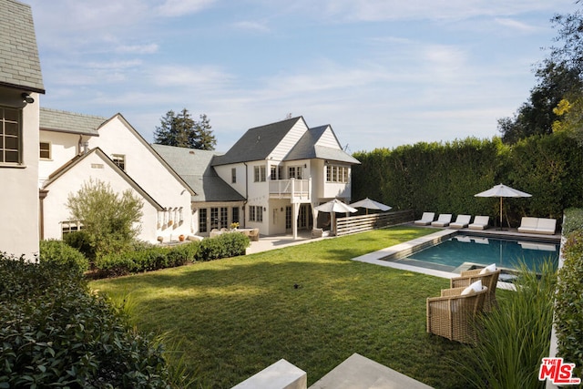 back of house featuring a balcony, a yard, and a patio area