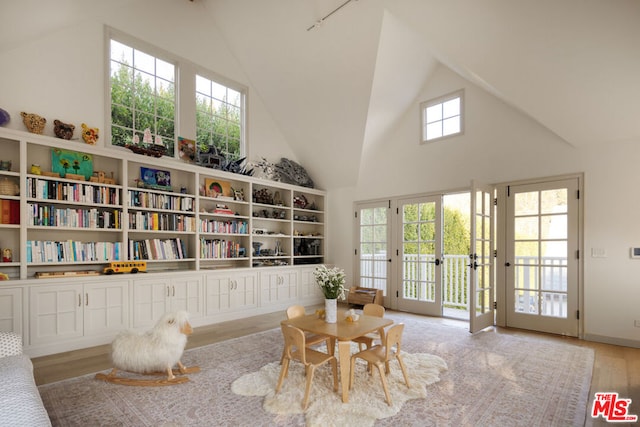 sitting room featuring high vaulted ceiling and light wood-type flooring