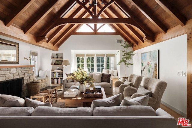 living room with beamed ceiling, a stone fireplace, wooden ceiling, and high vaulted ceiling