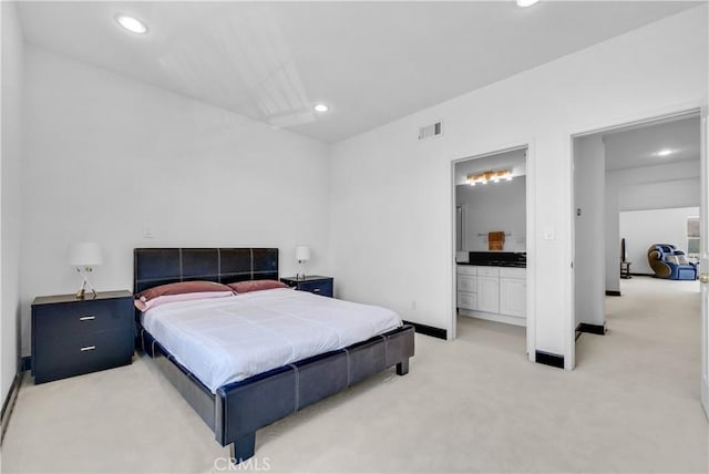 bedroom featuring light carpet and connected bathroom