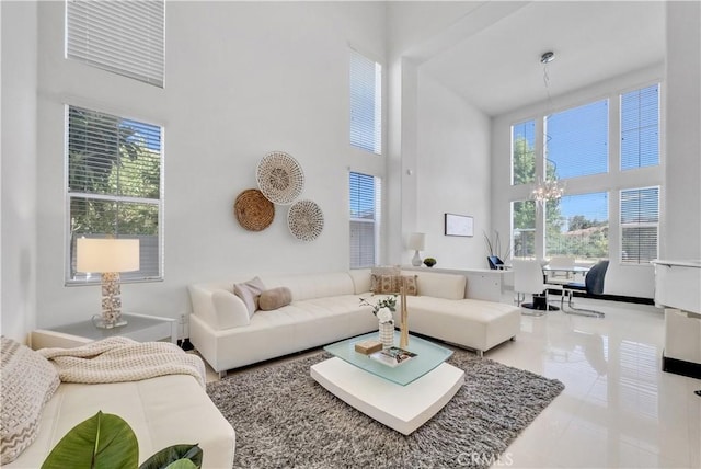 living room featuring tile patterned flooring, a towering ceiling, and a notable chandelier