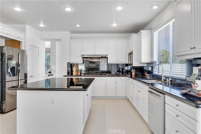 kitchen with white cabinetry, appliances with stainless steel finishes, sink, and a kitchen island