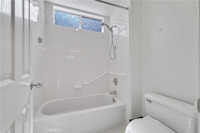 bathroom featuring tiled shower / bath combo and toilet